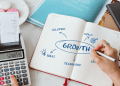 A founder mapping growth hacking experiments and scalable growth systems in a notebook, showing how structured testing turns ideas into repeatable business growth.