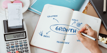 A founder mapping growth hacking experiments and scalable growth systems in a notebook, showing how structured testing turns ideas into repeatable business growth.