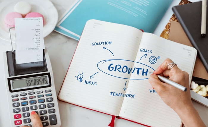 A founder mapping growth hacking experiments and scalable growth systems in a notebook, showing how structured testing turns ideas into repeatable business growth.
